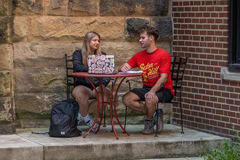 Students working at a table in a courtyard