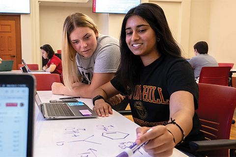 Students work around a whiteboard table