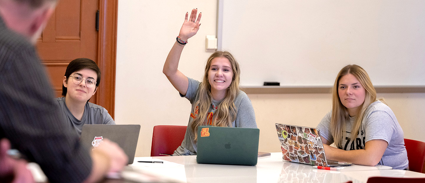 Smiling student raising her hand