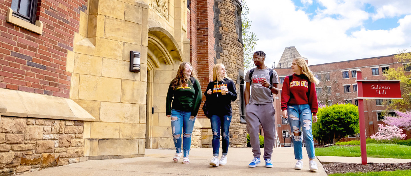 A group of Seton Hill students walking in front of the Sullivan building. 