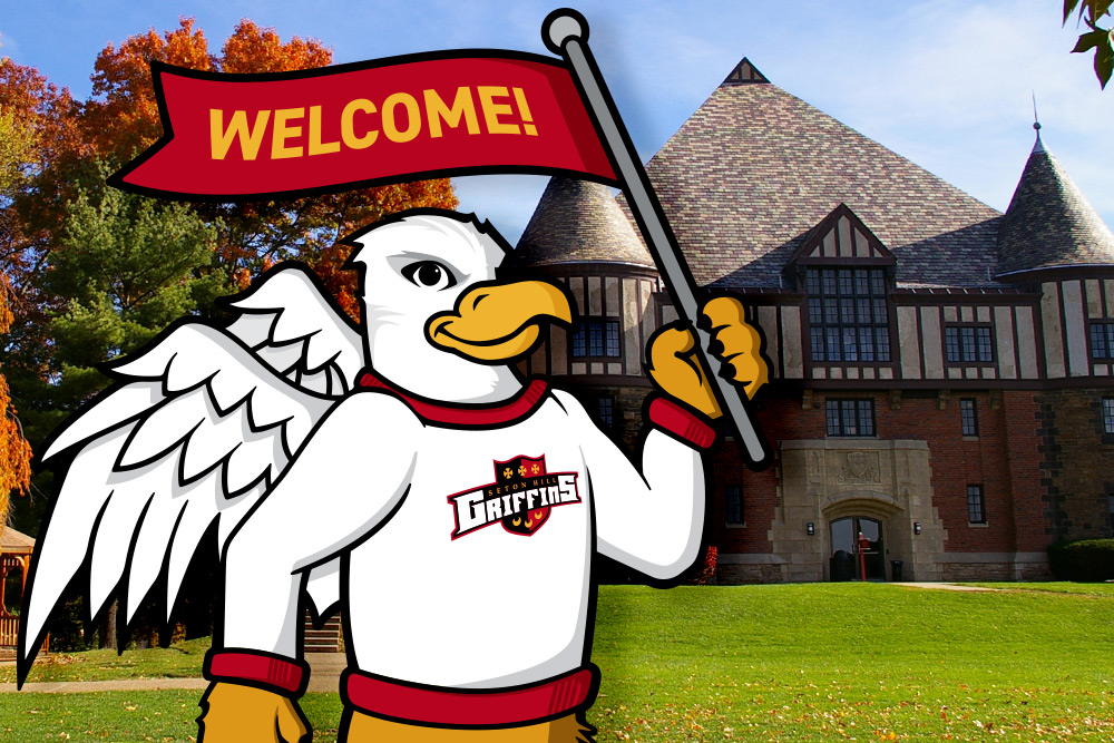 Griffin on campus in fall with Welcome sign