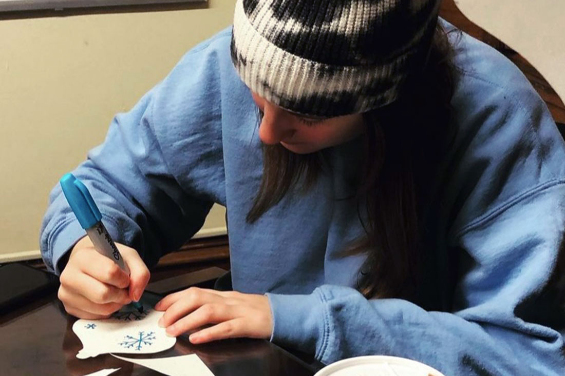 Student creating ornaments for the Giving Tree, the Honors service outreach with St. Anne.