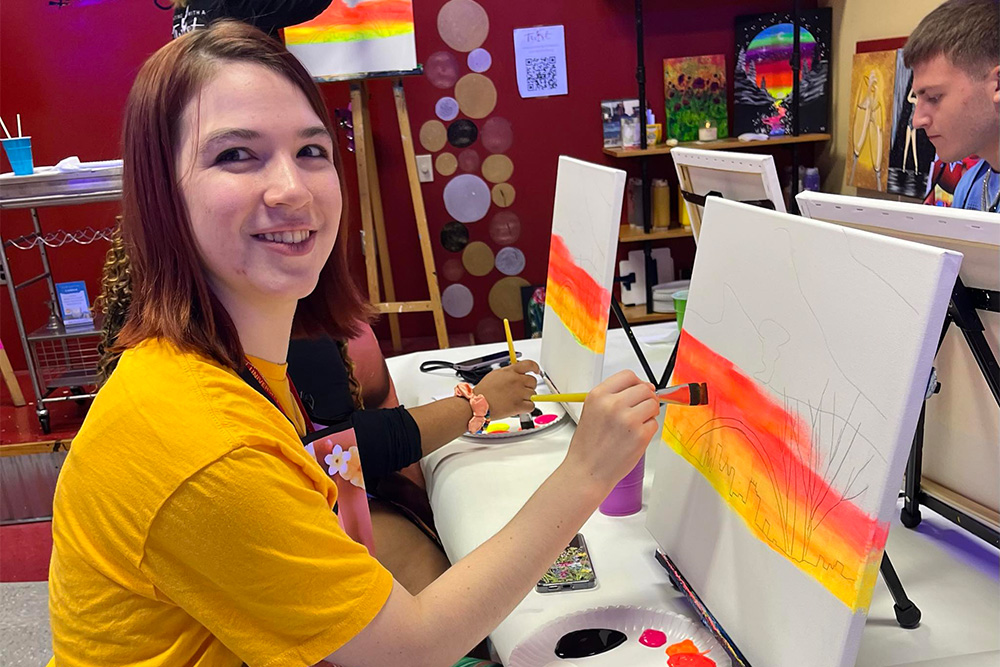 A student creates a painting during a Summer Academy event